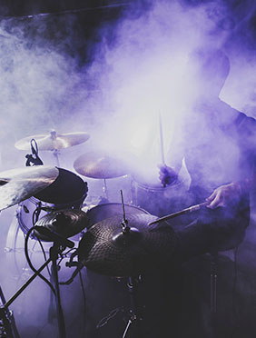 Man playing the drums in fog